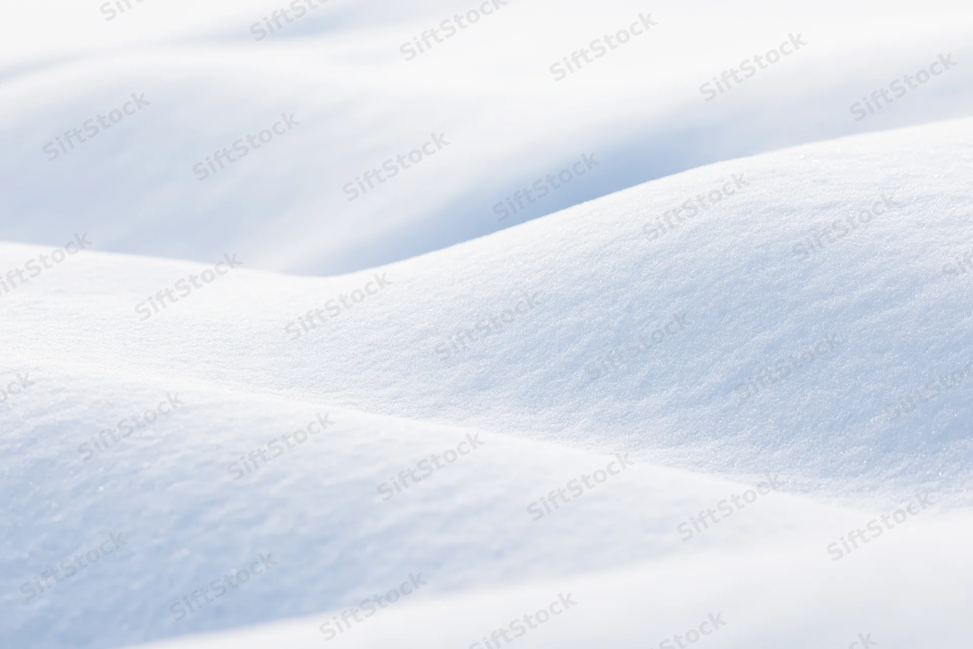 Closeup of smooth undulating fresh snow drifts in a winter landscape