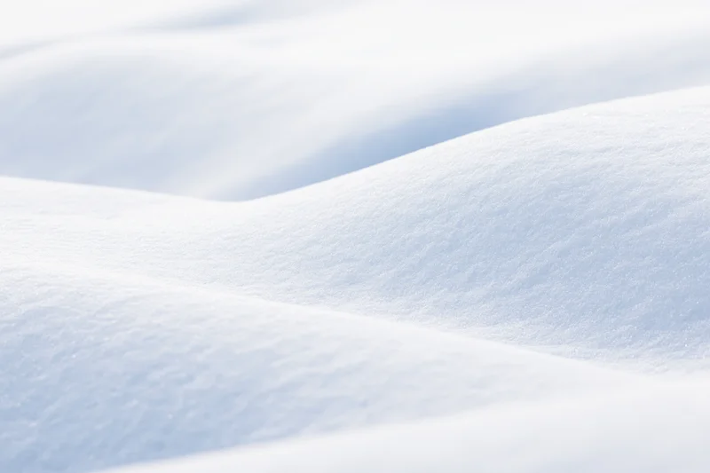 Closeup of smooth undulating fresh snow drifts in a winter landscape