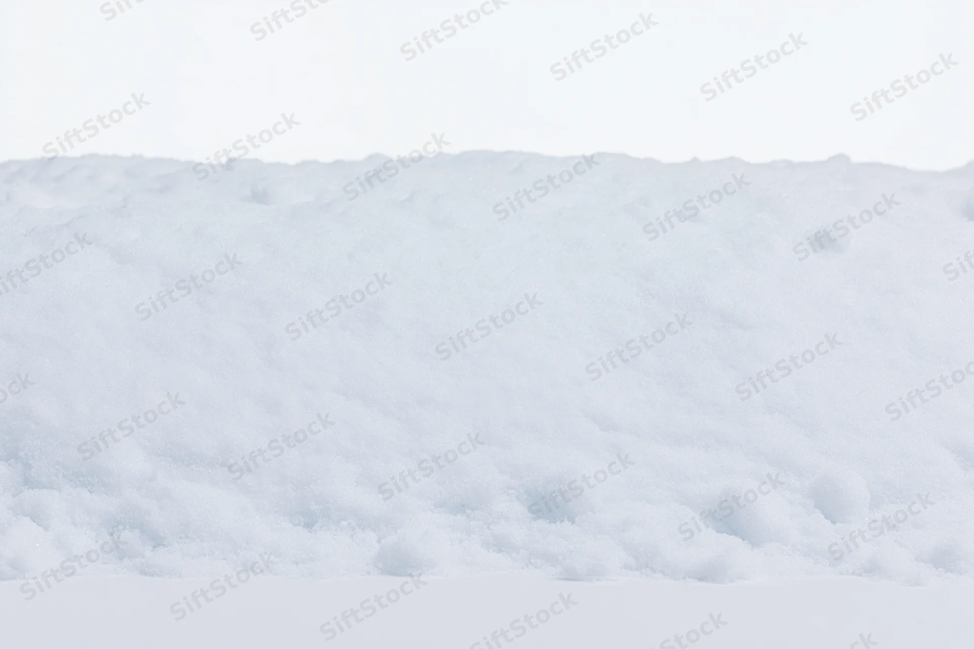 Close-up of a low mound of fresh white snow filling the bottom of the frame