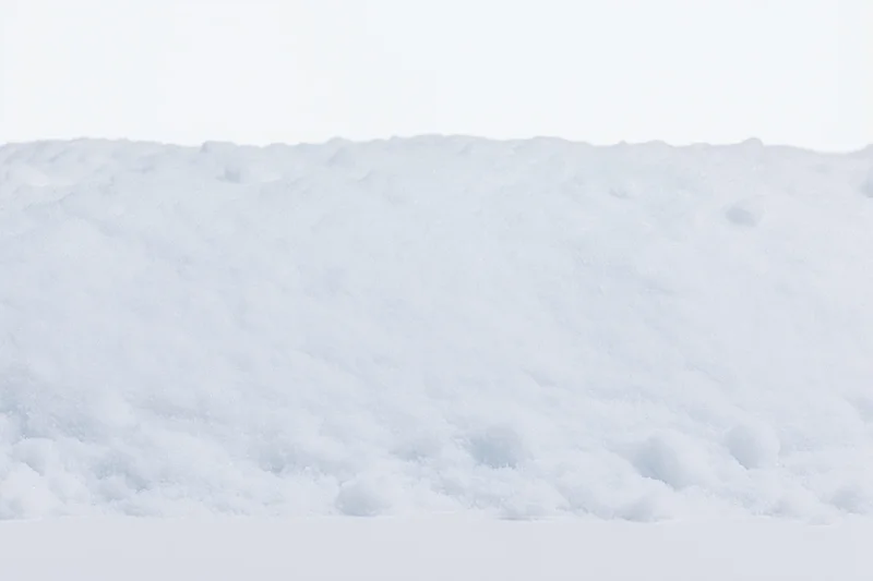 Close-up of a low mound of fresh white snow filling the bottom of the frame