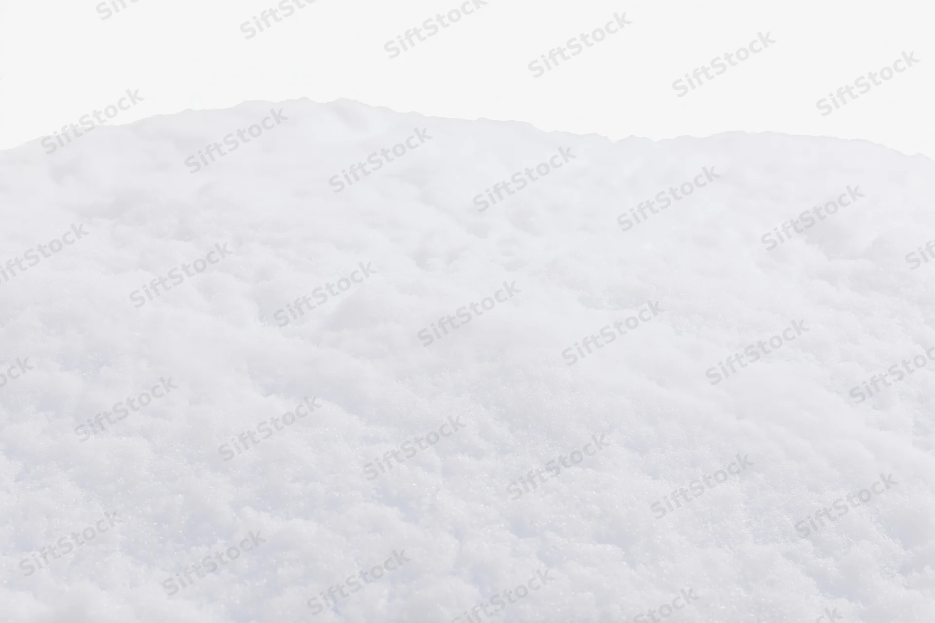 Closeup of a low mound of fresh white snow filling the bottom of the frame