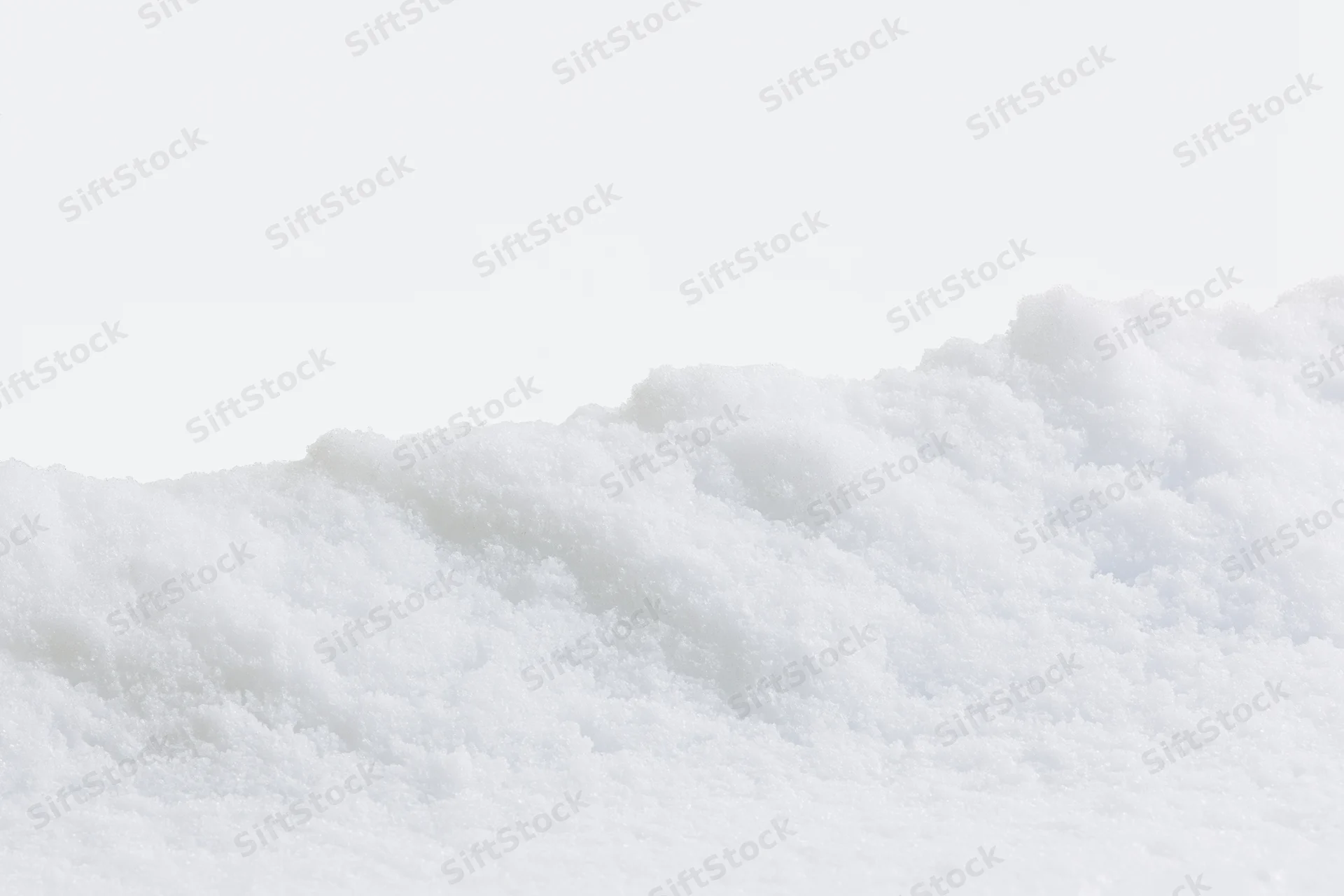 Close-up of a low snow drift edge running horizontally across the frame