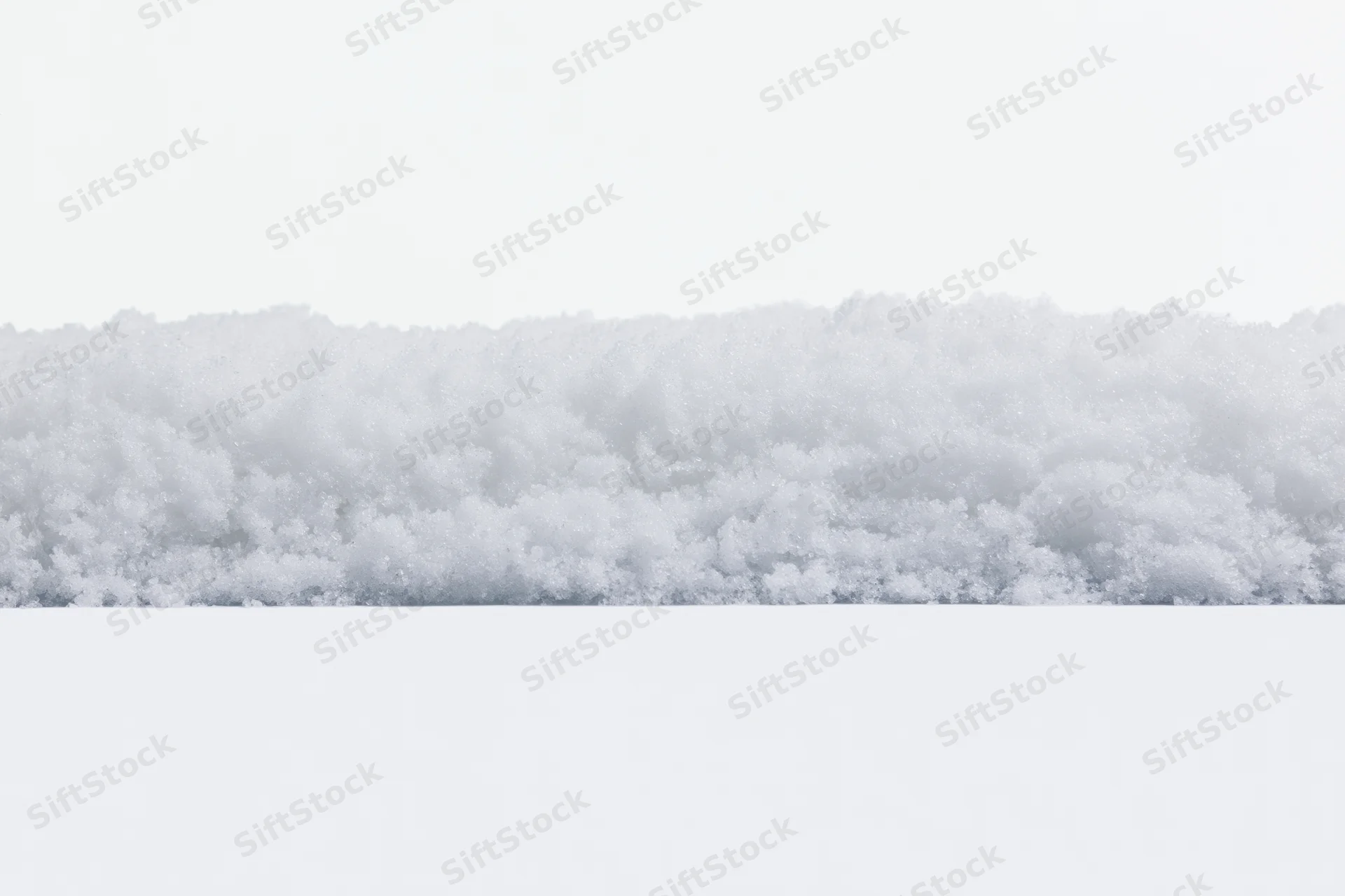 Close-up of a low snow drift edge running horizontally across the frame