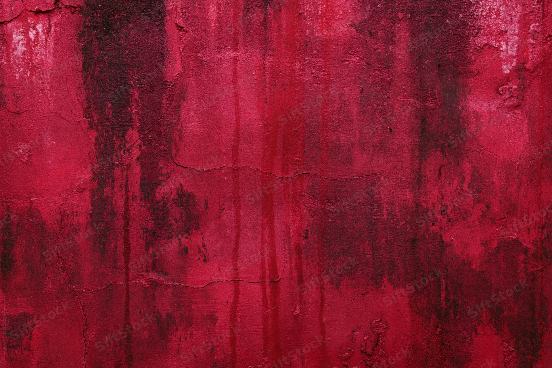 Weathered concrete wall with peeling red paint and cracked texture