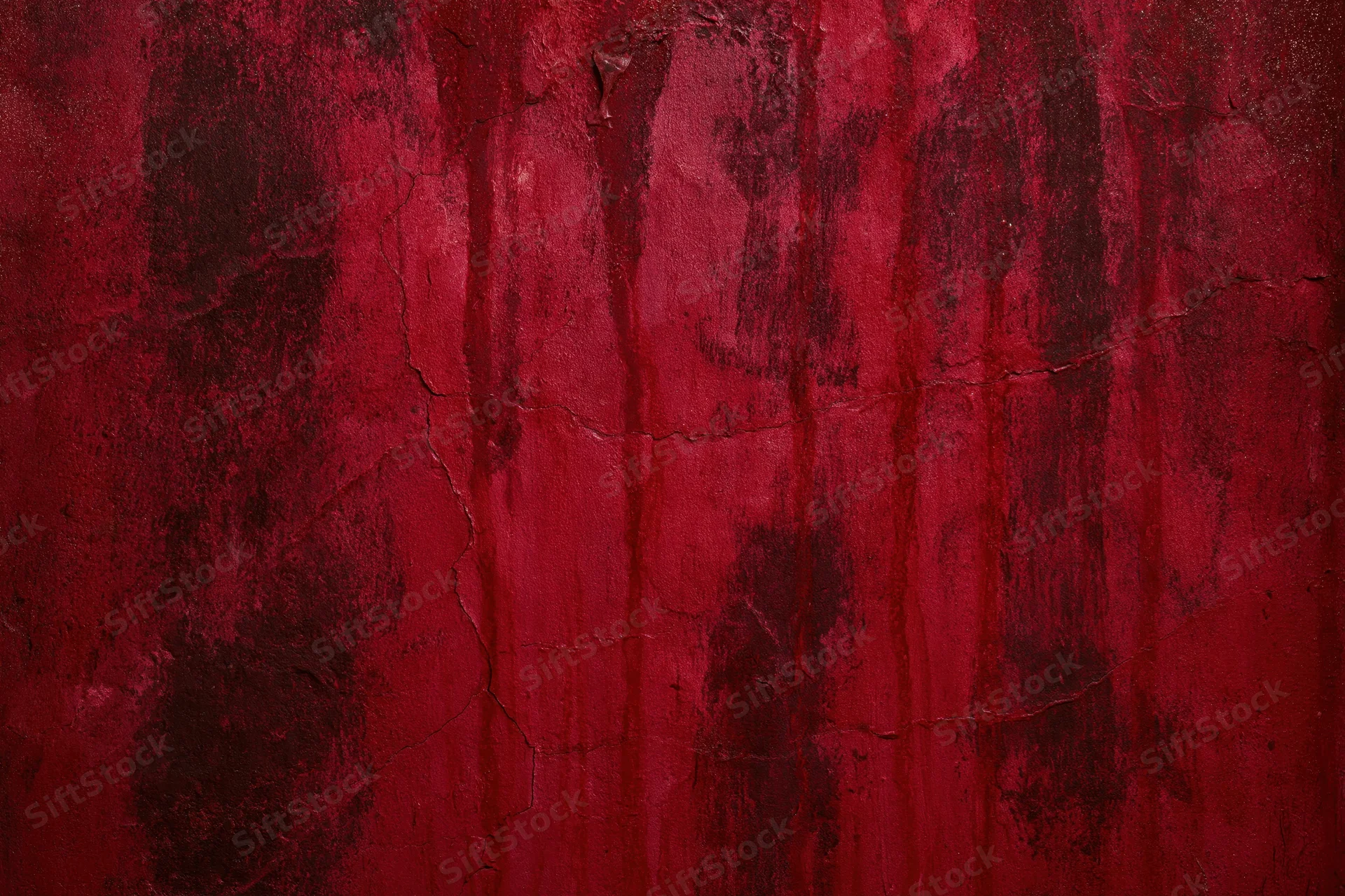 Weathered red concrete wall with cracked and peeling paint showing texture and decay