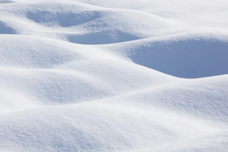 Closeup of undulating fresh snow drifts covering a snowy landscape