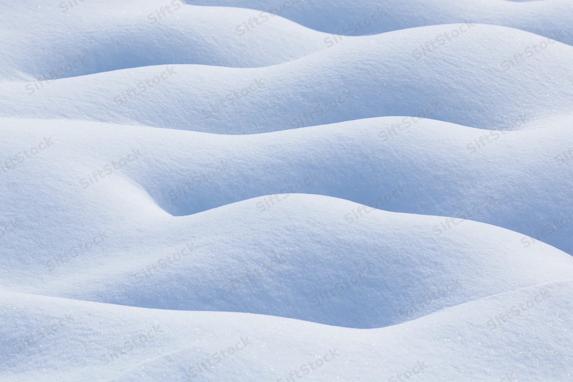 Close-up of undulating fresh snow drifts covering the ground in a winter landscape