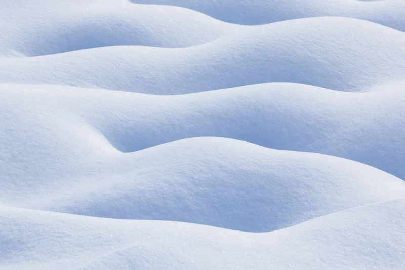 Close-up of undulating fresh snow drifts covering the ground in a winter landscape