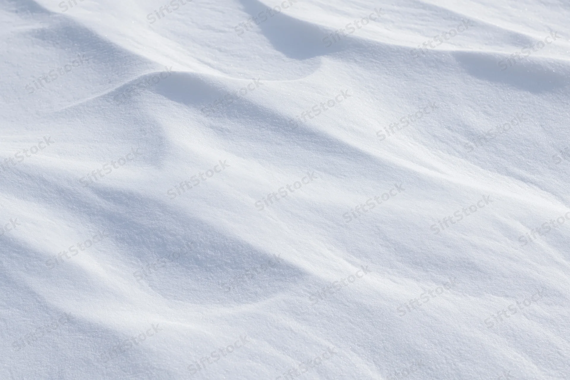 Wind-sculpted snow surface in close-up top-down view filling the frame