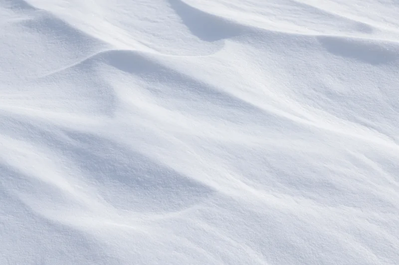 Wind-sculpted snow surface in close-up top-down view filling the frame