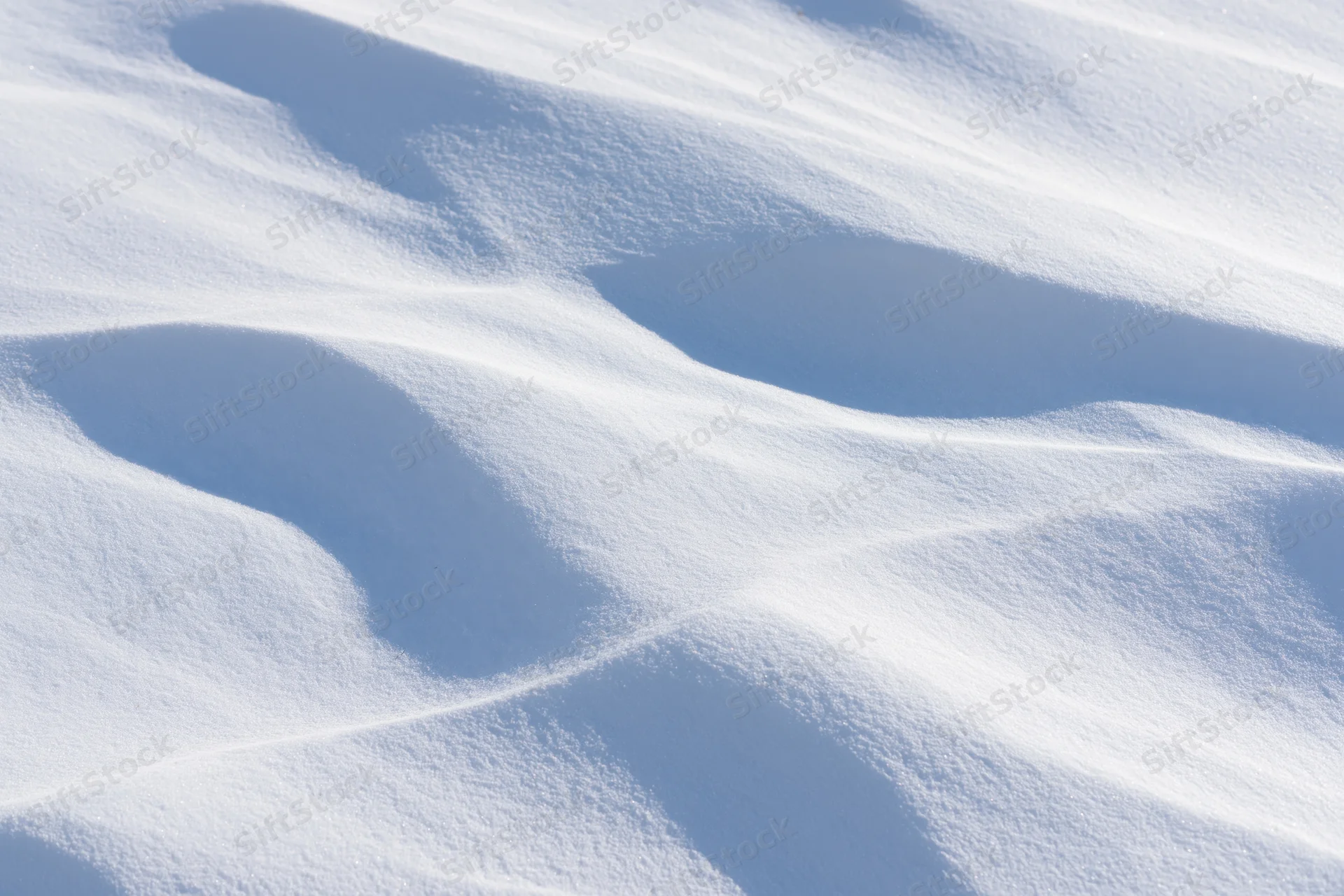 Wind-sculpted snow surface in close-up top-down view