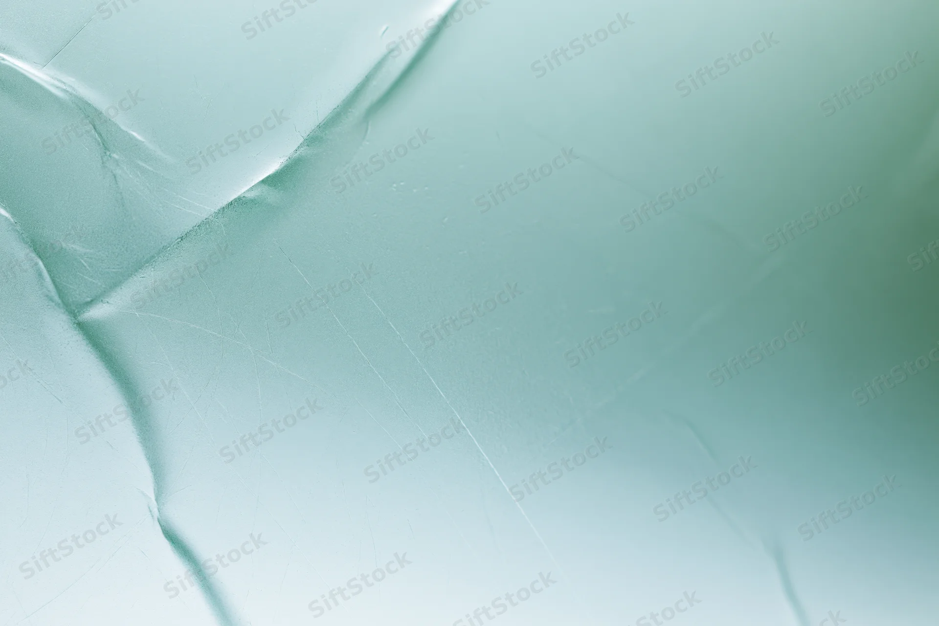 Close macro view of frosted translucent glass surface with subtle cracks and light reflections
