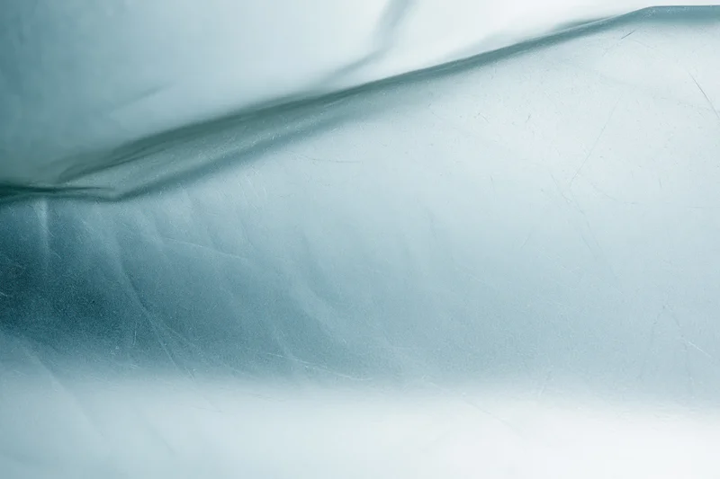 Close macro view of frosted translucent glass surface with soft light and shadow patterns
