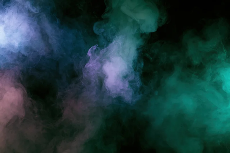 Colored smoke clouds drifting and billowing against a dark background