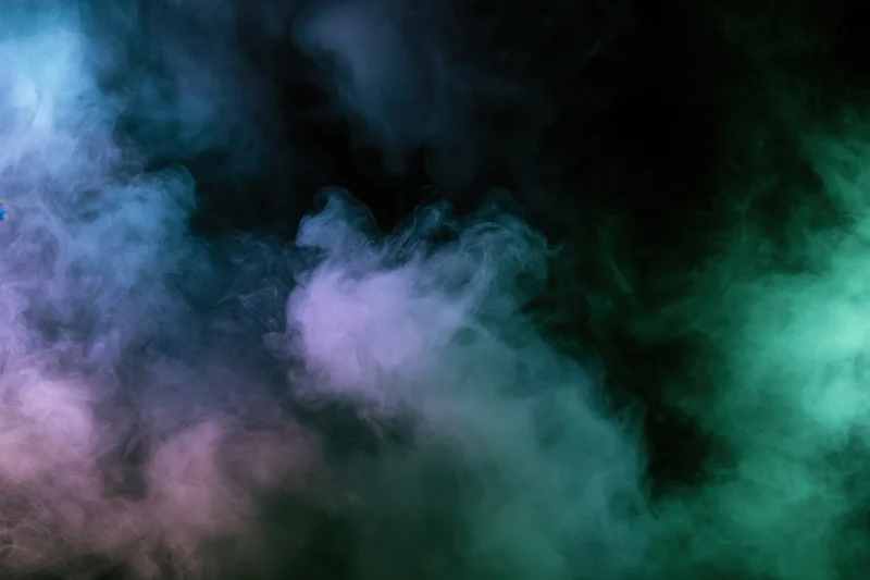 Colored smoke clouds drifting and billowing against a dark background