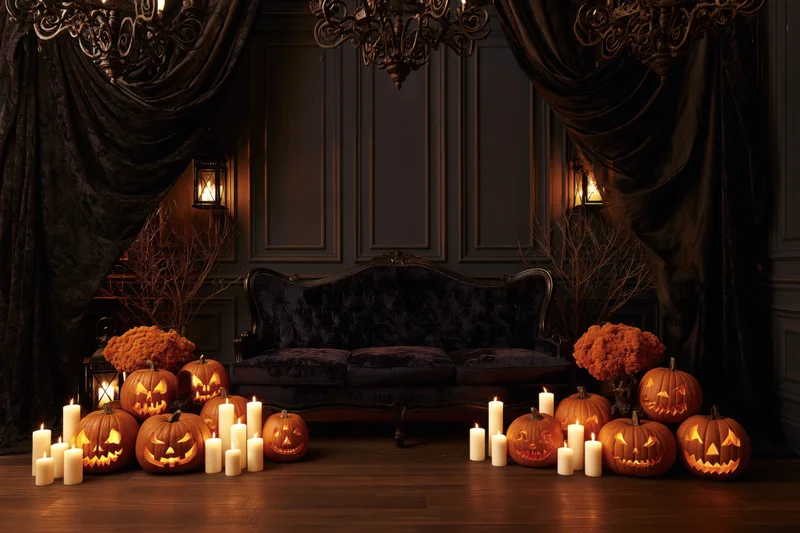 Dark victorian living room decorated with carved pumpkins and candles for halloween