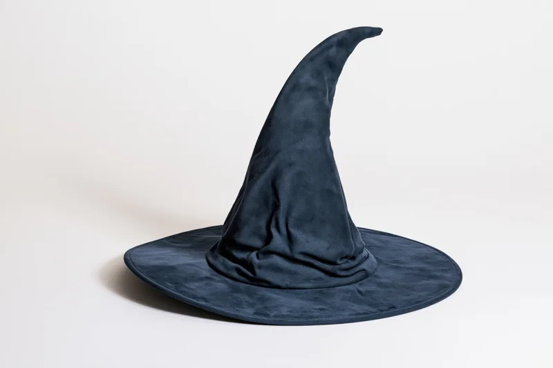 Dark navy blue witch hat with tall curved pointed crown and wide brim on white background