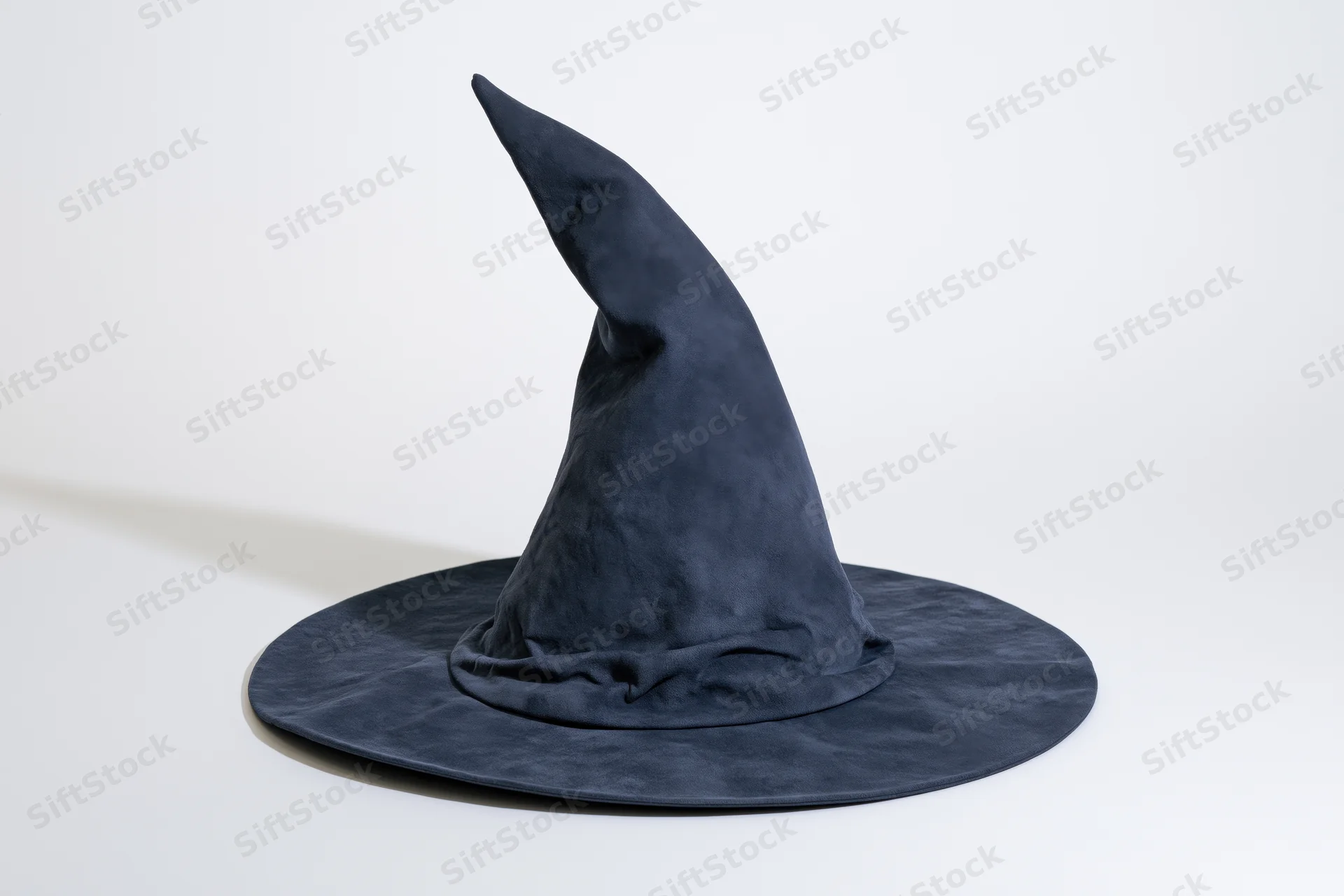 Dark navy blue witch hat with tall curved pointed crown and wide brim on white surface
