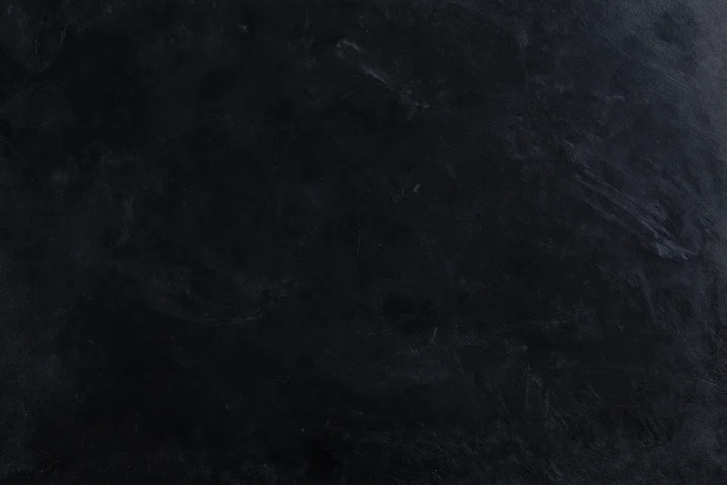 Dark weathered concrete wall surface with textured rough finish filling the frame