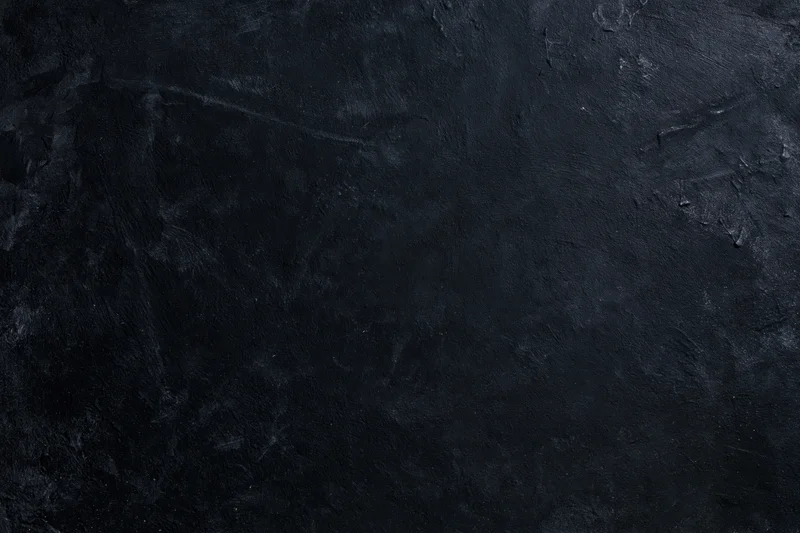 Dark weathered concrete wall surface with rough texture and subtle cracks filling the frame