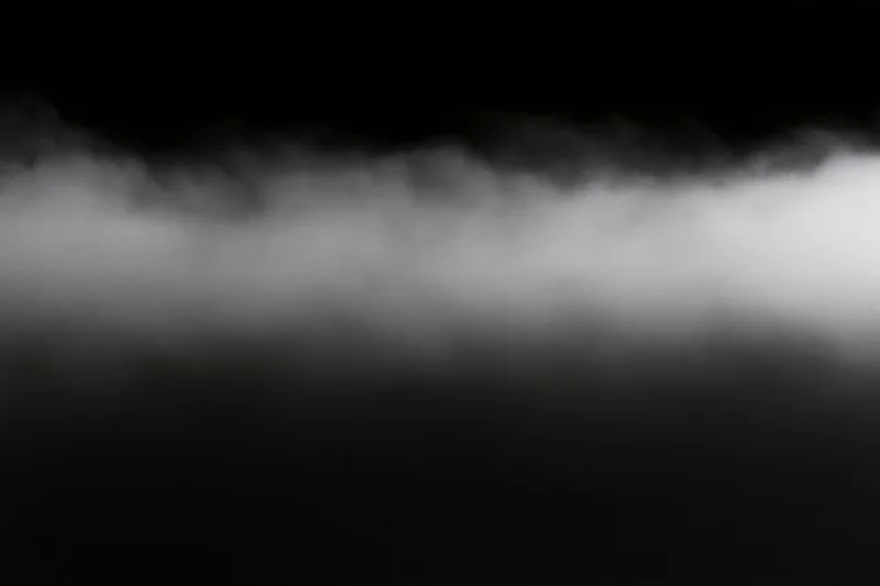 Dense white fog rolling horizontally across the frame forming a soft gradient band against dark background