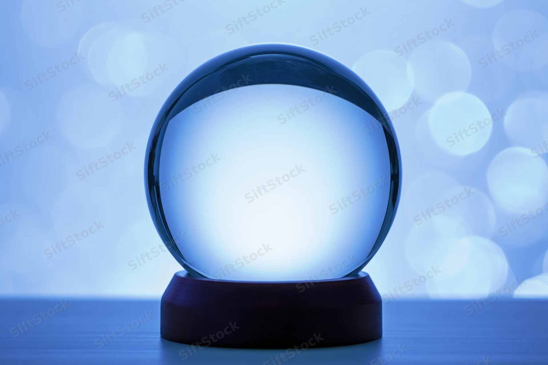 Glowing crystal sphere on a dark wooden base against a blue bokeh background