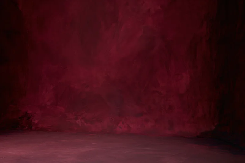 Textured red painted canvas wall in empty photography studio interior