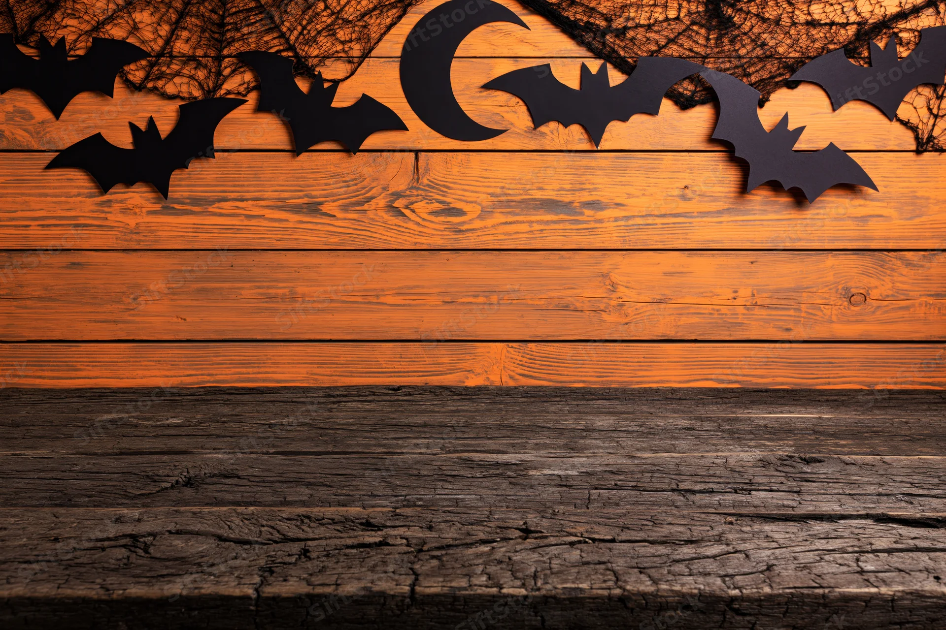 Rustic wooden table with halloween decorations above in orange and black