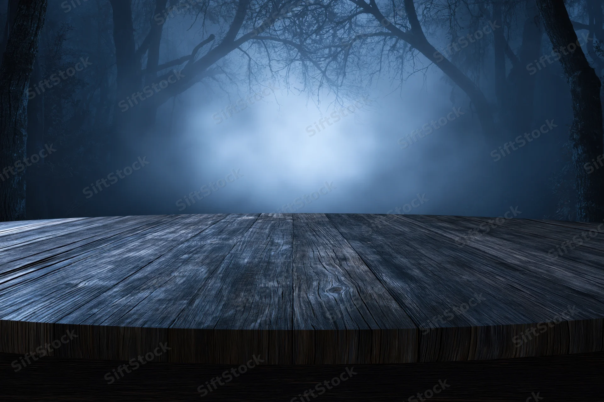 Weathered wooden plank table in a misty dark forest at night