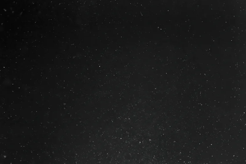 Fine dust particles and light specks suspended in dark space