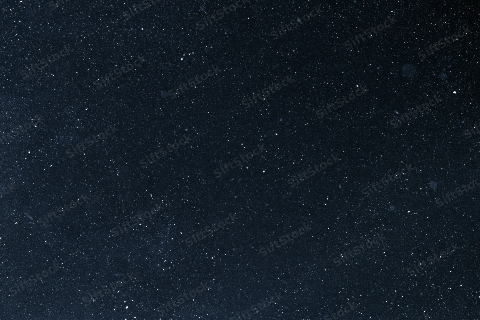 Dark night sky filled with scattered stars and floating dust particles