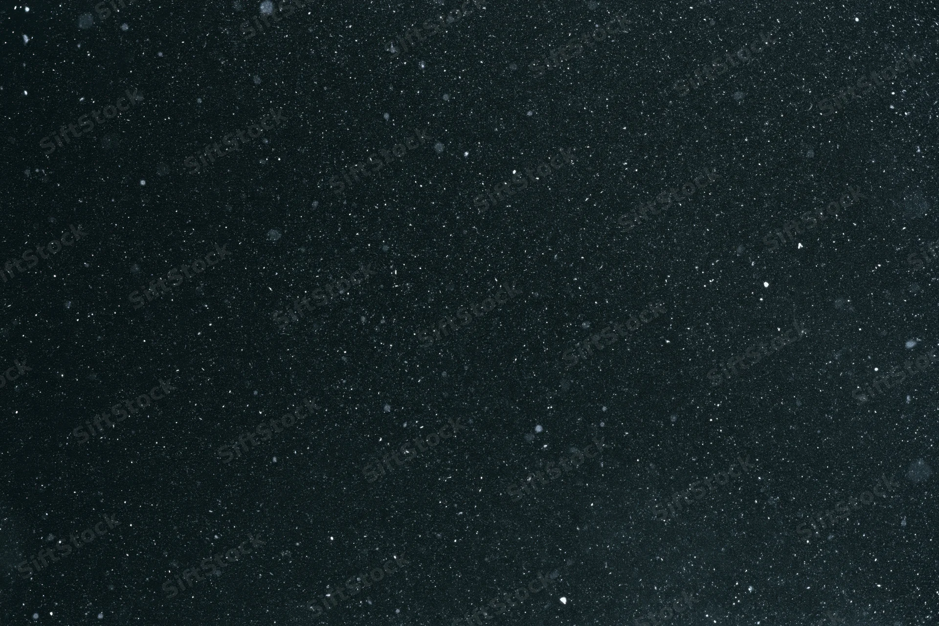 Fine dust particles and light specks suspended in dark space