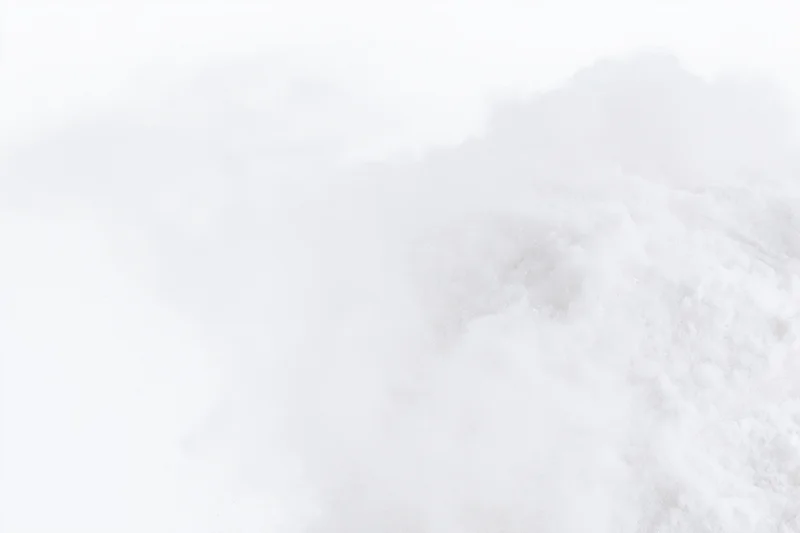 Fine white powder exploding midair against pure white background