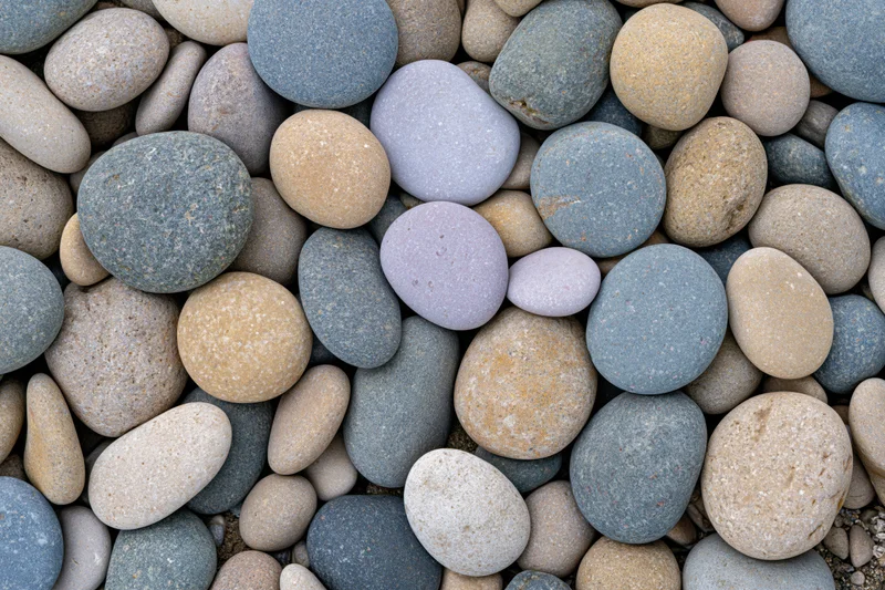 Smooth rounded river pebbles and beach stones in a flat lay close-up arrangement