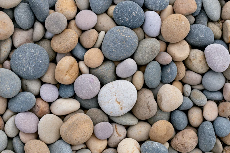 Smooth rounded river pebbles and beach stones in a flat lay close-up arrangement