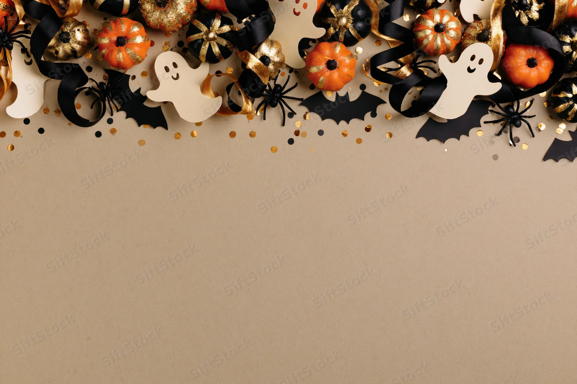 Halloween decorations arranged along the top edge of a flat surface with copyspace below