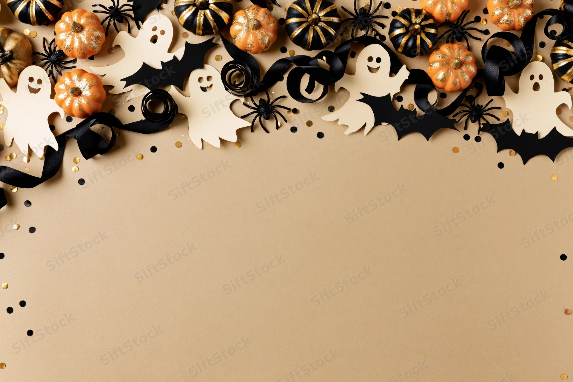 Halloween decorations arranged along the top edge on beige background with copyspace below