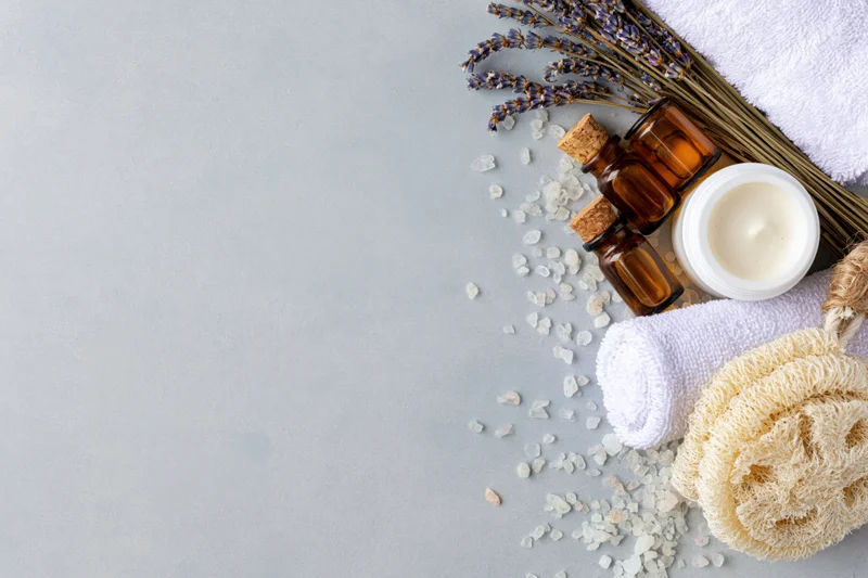 Skincare and spa products arranged in flat lay on gray surface with copyspace