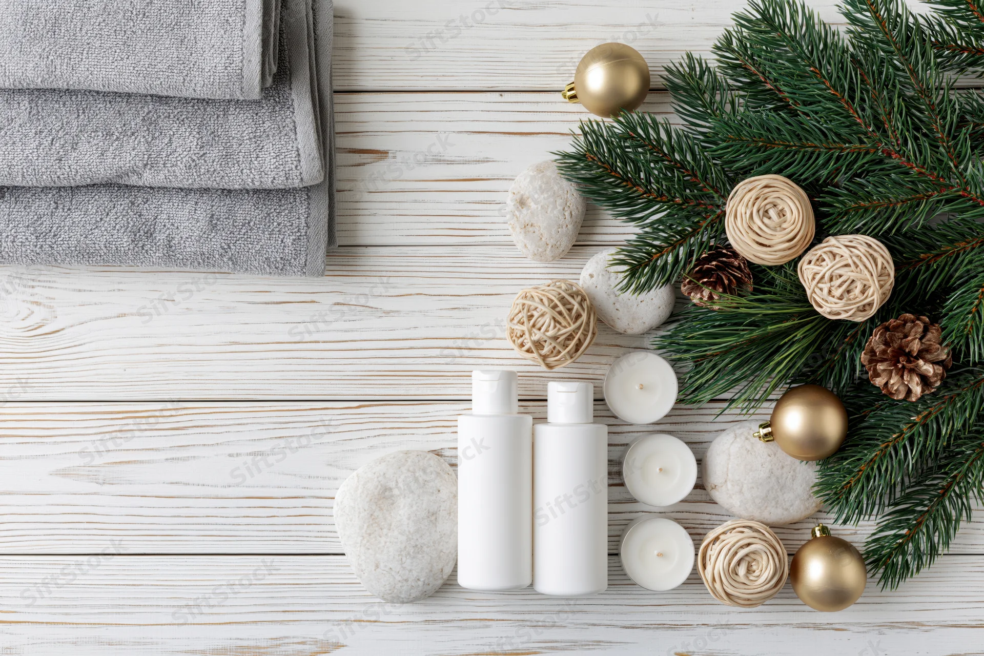 Spa and skincare products arranged with christmas decor on white wooden surface