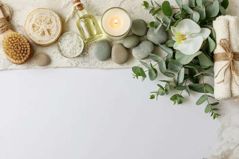 Spa and wellness items arranged along the top edge of a white surface with copyspace below