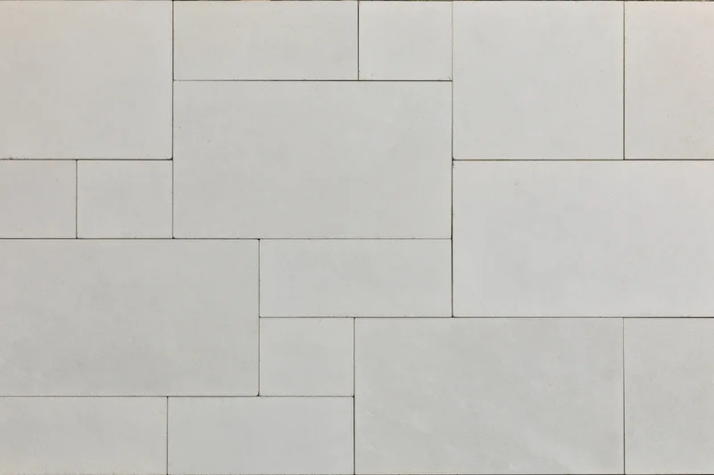 Overhead view of light grey concrete paving slabs arranged in a geometric pattern for outdoor flooring