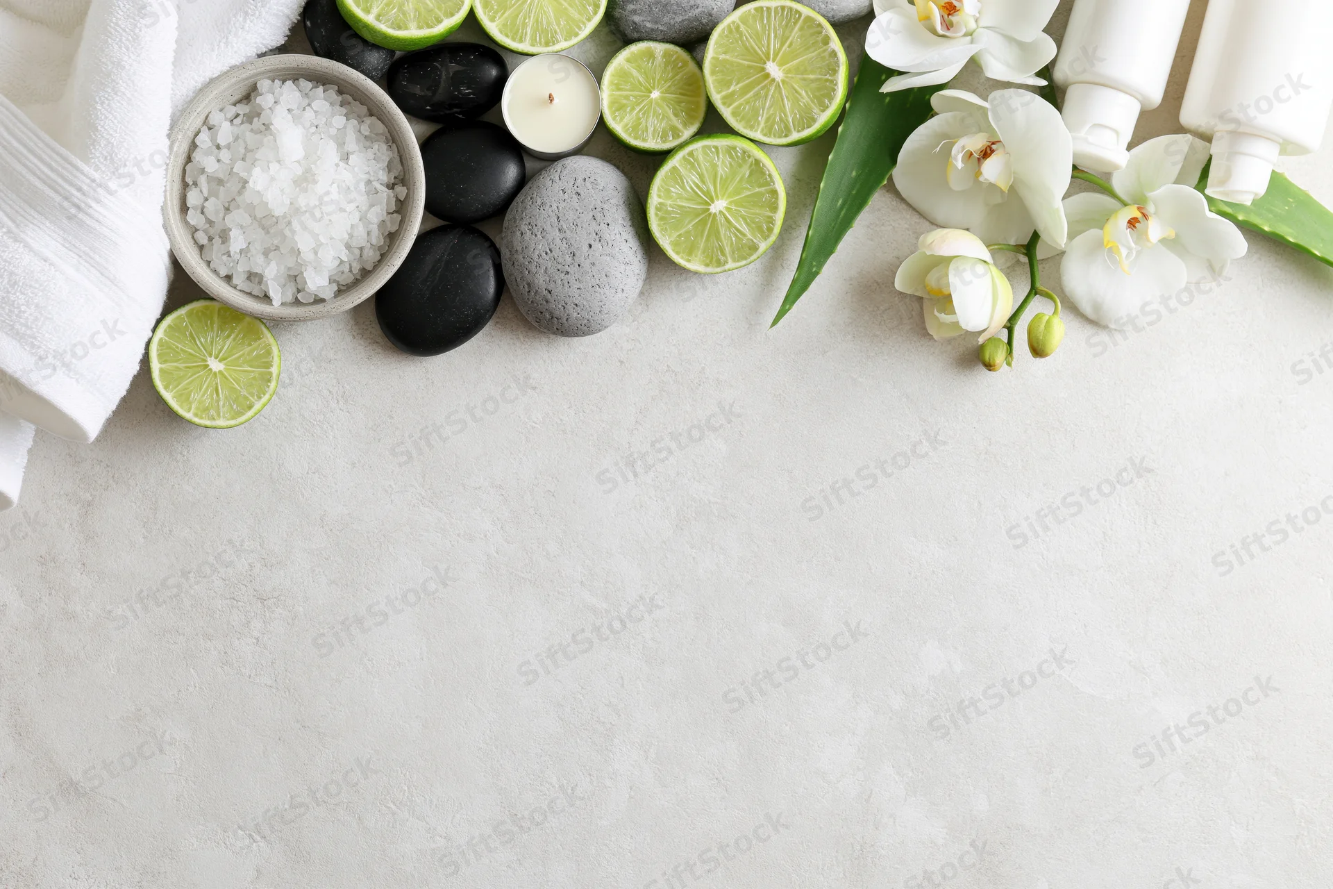 Spa wellness products arranged along top edge of textured white surface with copyspace below