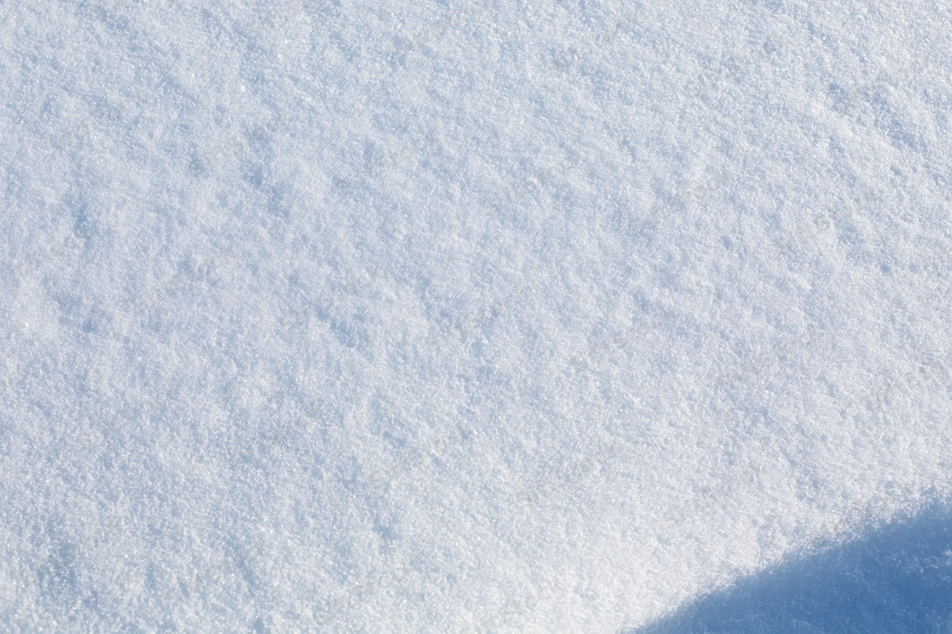 Undisturbed snow surface filling the frame with soft texture and shadow in corner