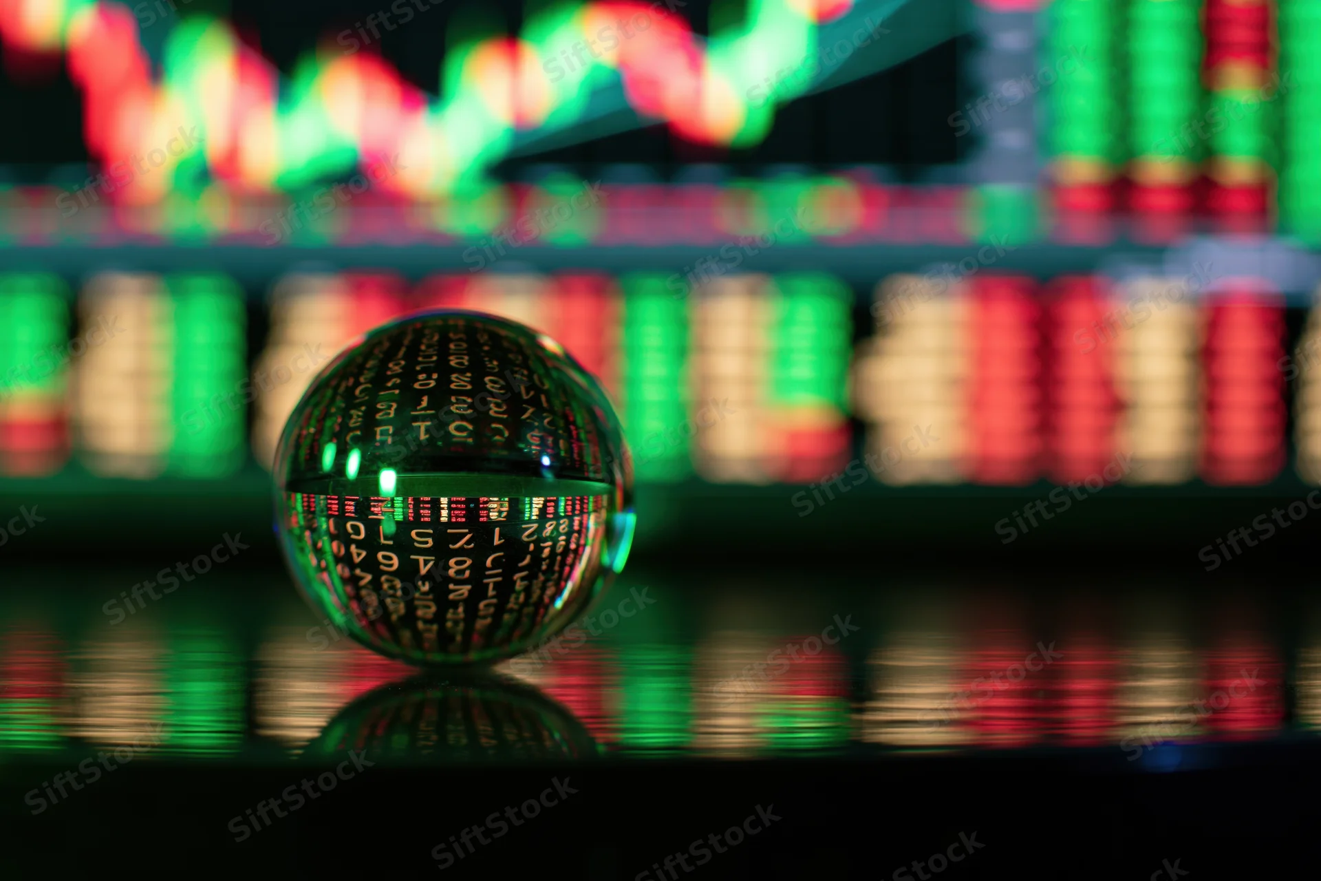 Glass crystal ball resting on reflective surface with stock market data displayed in background