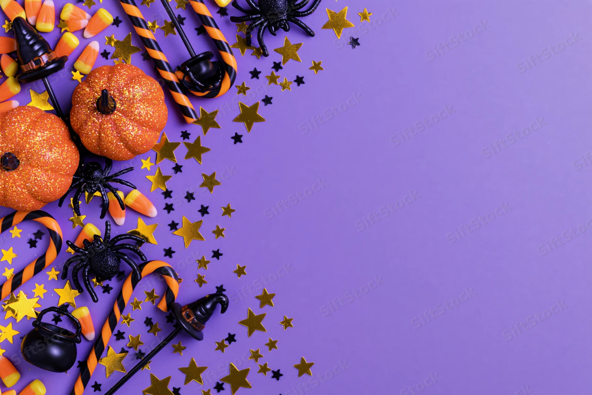 Halloween decorations arranged in corner on purple background with copyspace