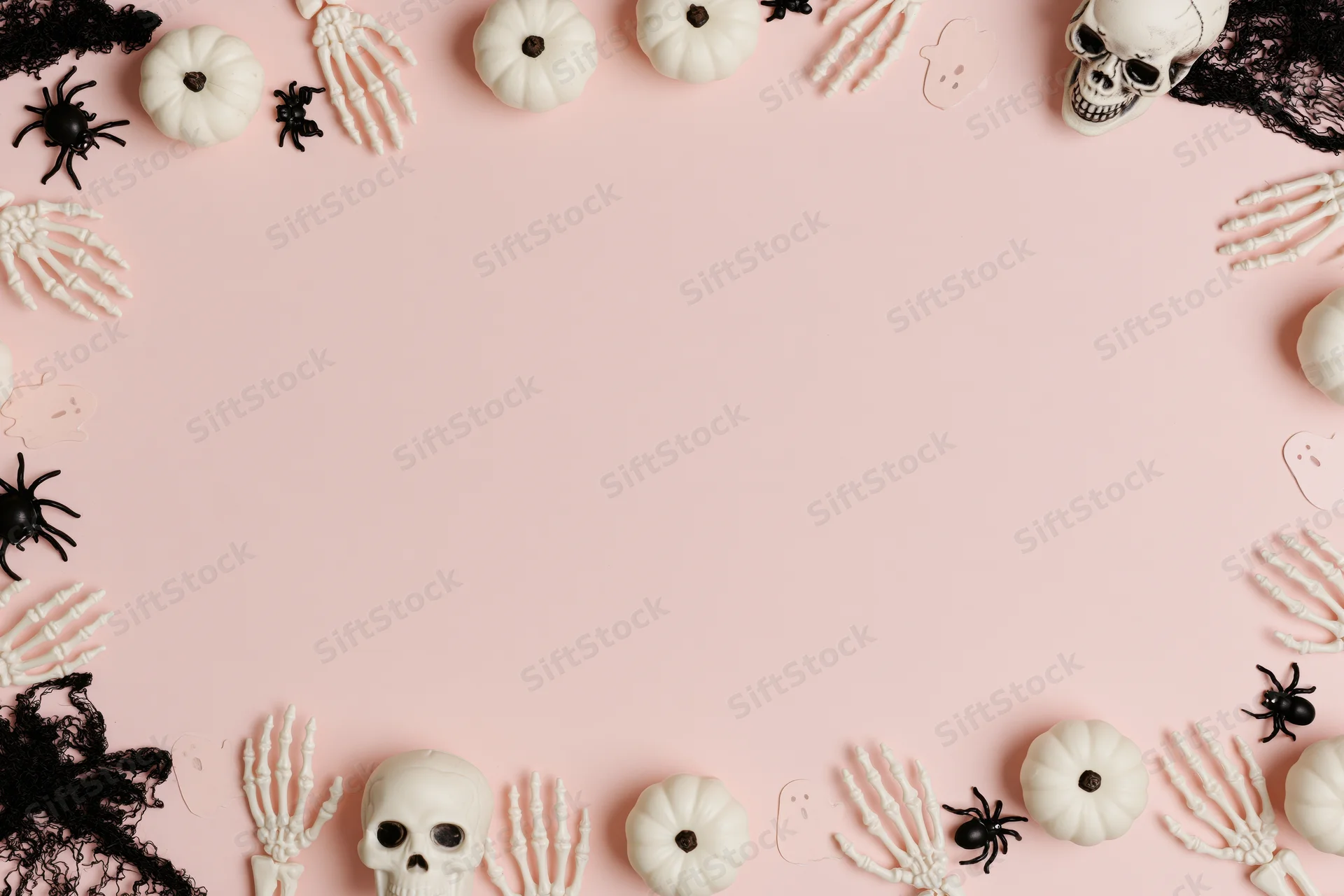 Halloween decoration border with skulls, pumpkins, spiders and lace on pink background