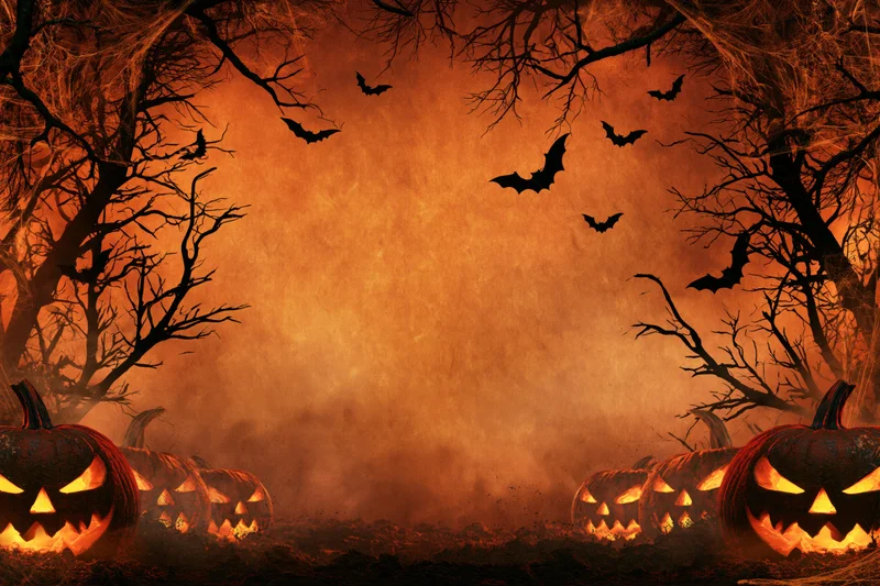 Carved jack-o-lanterns glowing at night in a spooky forest with flying bats and bare trees