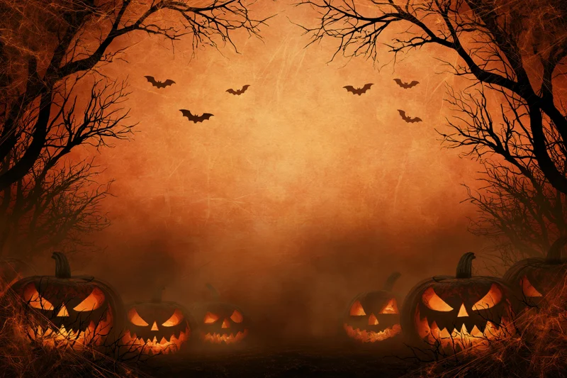 Carved jack-o-lanterns glowing in a misty forest at night with flying bats and bare trees