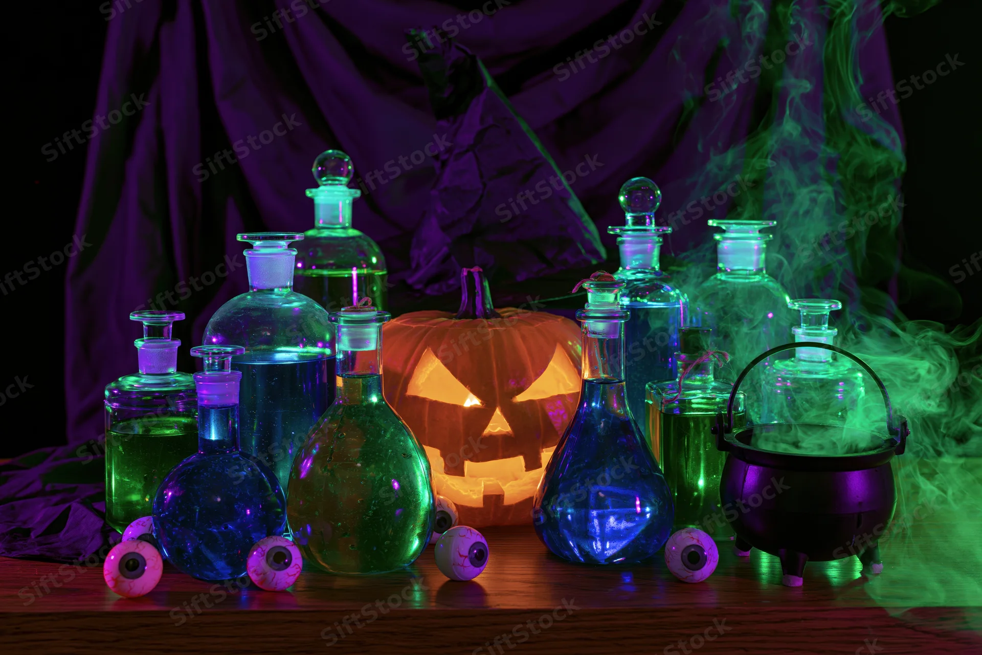 Witch's table with glowing potion bottles and jack-o'-lantern surrounded by smoke and eyeballs