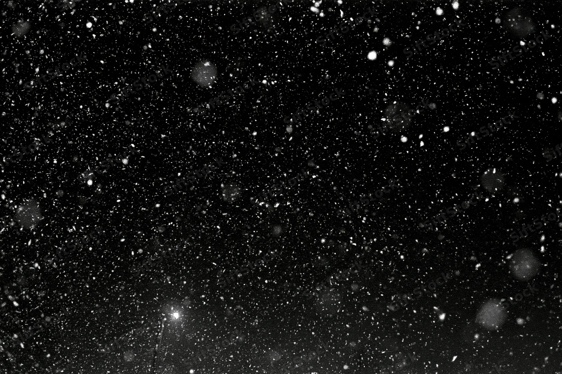 Heavy snowfall falling against a black night sky